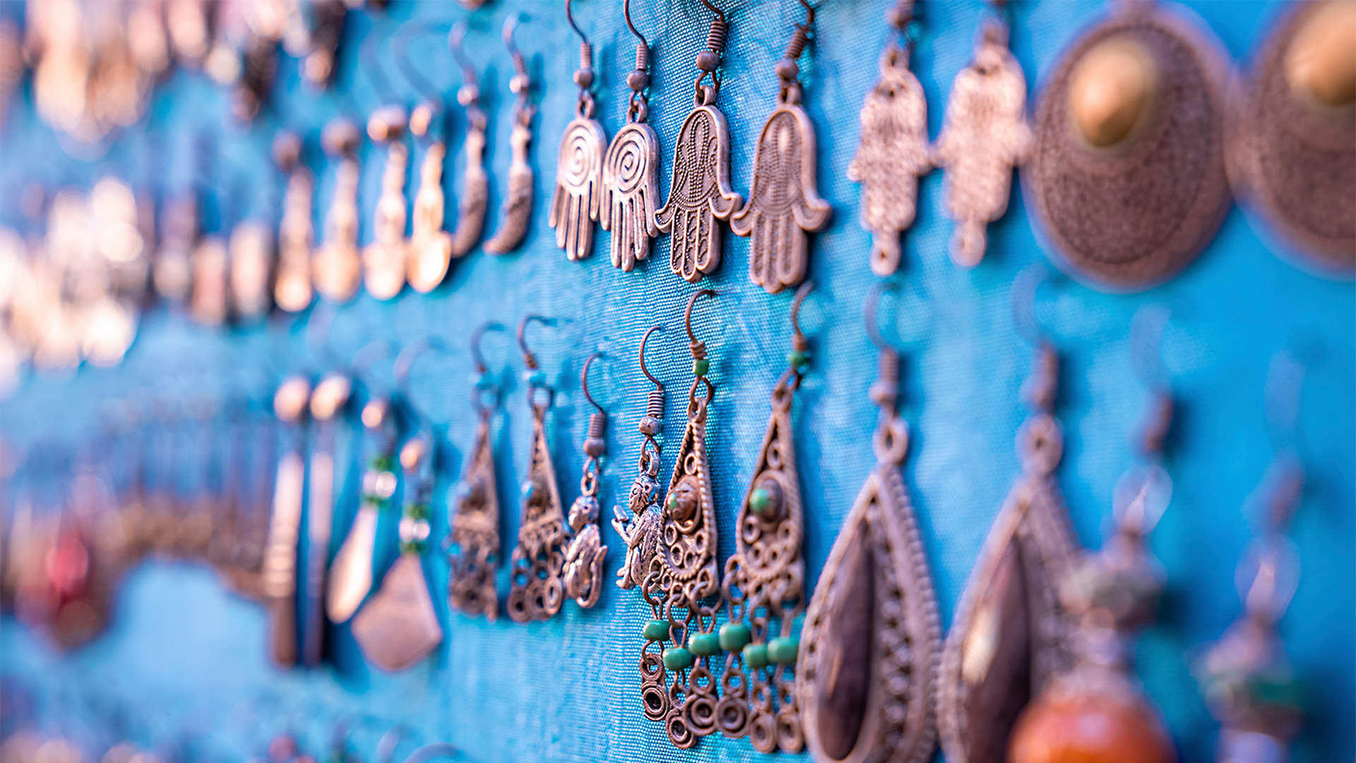 Hikaru sits smiling in a bright and cozy craft room filled with handmade crafts and cheerful colors, creating a welcoming and joyful atmosphere